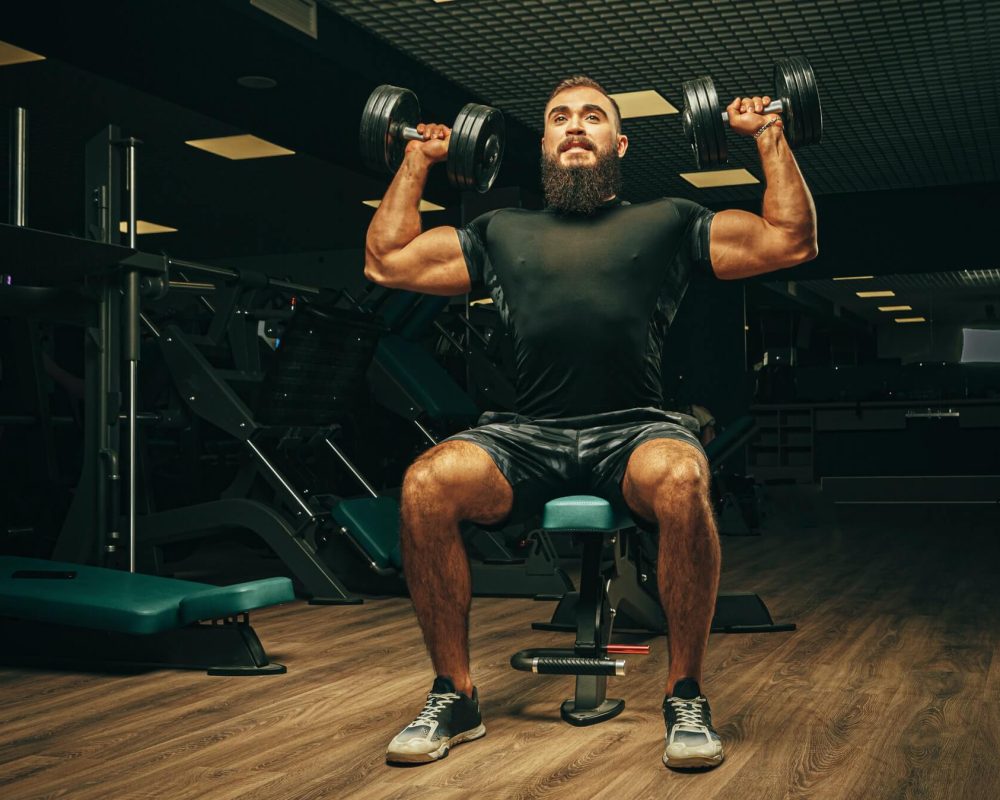 muscular-young-man-lifting-weights-in-a-dark-gym-1.jpg